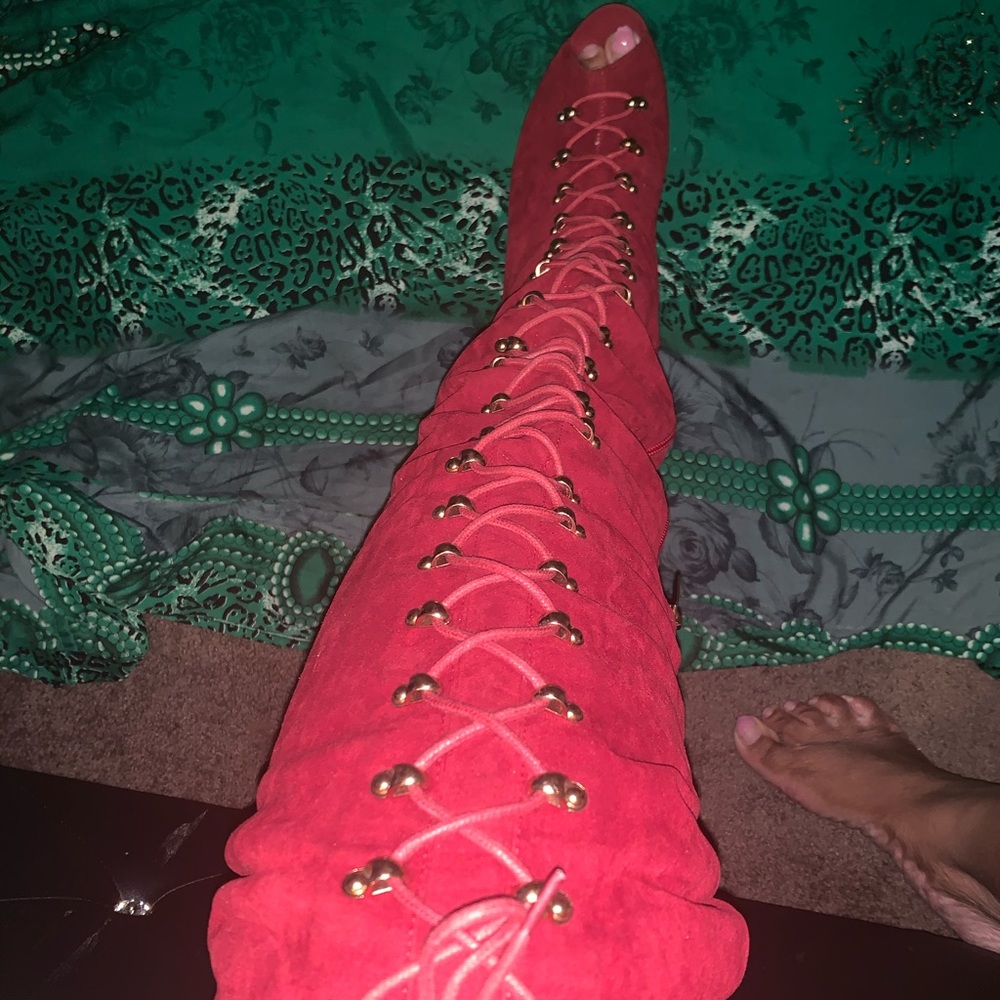 Thigh red lace up boots with heel.